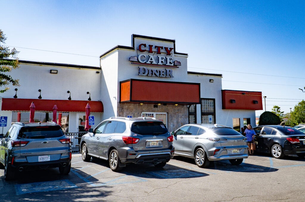 Front entrance of City Cafe Diner in Huntsville, Alabama, with red awning and parking area.